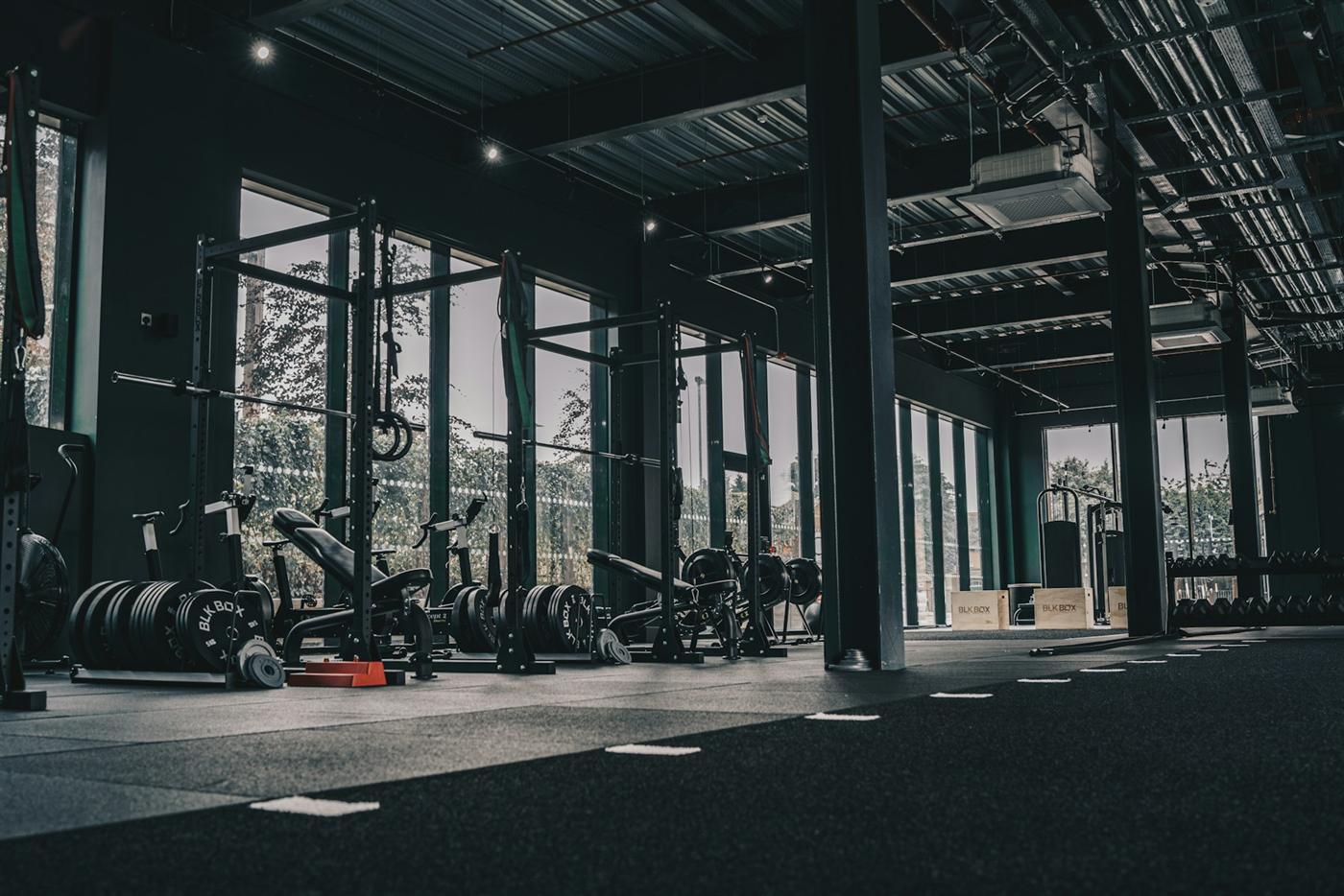 A wide industrial training floor with racks, rubber flooring and tall windows