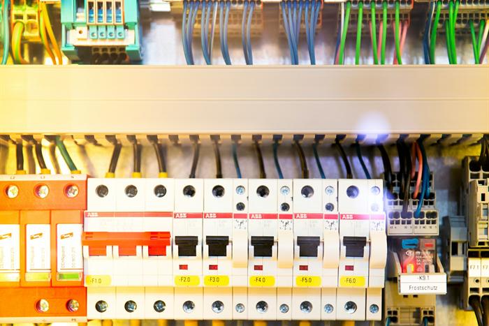 A large industrial electrical panel with colour-coded breakers and terminals