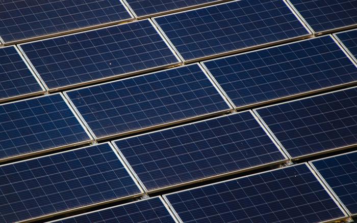 A large rooftop array of blue solar panels