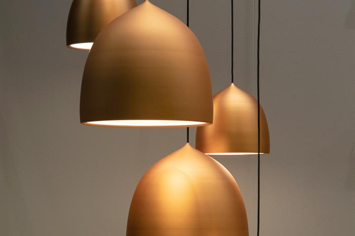 A cluster of copper pendant light fittings hanging at different heights